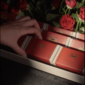 A luxurious box decorated with natural roses containing 24 boxes of premium Swiss chocolates.